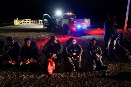 ARCHIVO - Varios migrantes esperan ser procesados por las autoridades estadounidenses luego de cruzar la frontera de Estados Unidos con México, el 6 de enero de 2023, cerca de Yuma, Arizona. (AP Foto/Gregory Bull, Archivo)