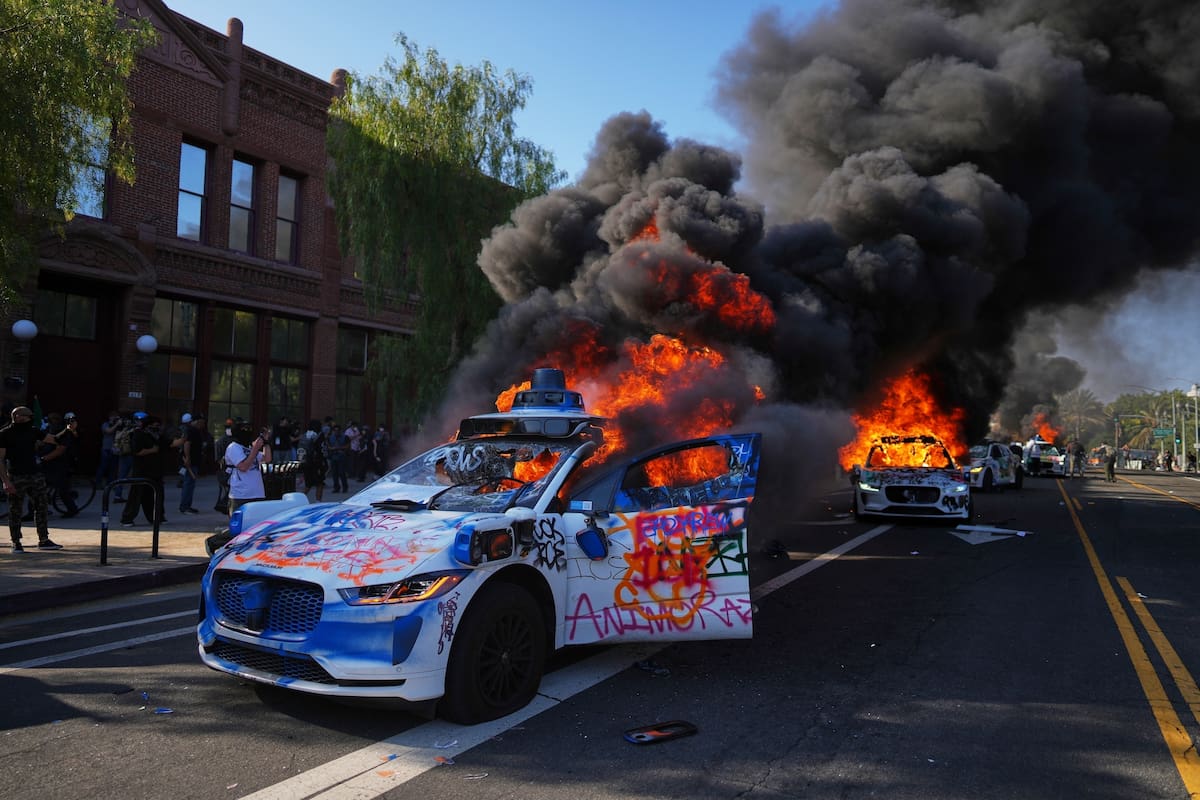 ARCHIVO – Varios taxis de Waymo arden cerca del Centro Metropolitano de Detención en el centro de Los Ángeles, el domingo 8 de junio de 2025, tras las potestas contra las redadas de inmigración realizadas la noche anterior. (AP Foto/Eric Thayer, Archivo)