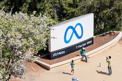 ARCHIVO - Visitantes toman fotos junto a un letrero afuera de la sede de Meta el 26 de marzo de 2026, en Menlo Park, California. (AP Foto/Noah Berger, archivo)