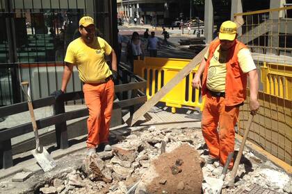 Ignacio Lugo junto a su compa?ero trabajan con bajo el sol en pleno microcentro.
