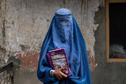 Arefeh, una mujer afgana de 40 años, sale de una escuela clandestina en Kabul, el sábado 30 de julio de 2022 (AP Foto/Ebrahim Noroozi, archivo)