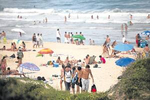 Arena blanca, olas y morros, típica postal del sur brasileño que en Praia do Rosa tiene una particularidad: parece ser tierra sólo para jóvenes