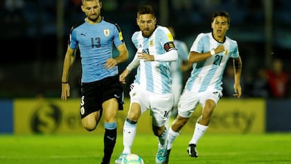 Lionel Messi, capitán argentino, deja atrás a Gastón Silva, de Uruguay. El clásico del Río de la Plata por las eliminatorias, previsto para el próximo 26 de marzo, podría postergarse.