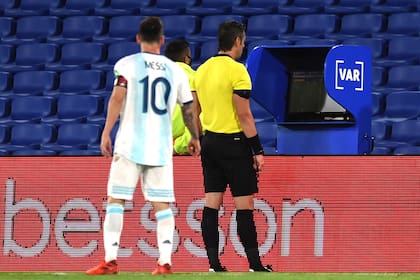 Lionel Messi espía cómo Raphael Claus observa la revisión de la jugada de su gol, que no será convalidado.