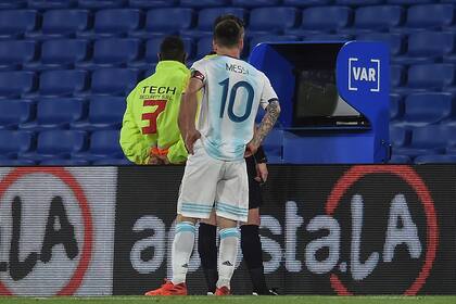 Lionel Messi acude al monitor de VAR para inspeccionar lo que ve el árbitro Claus; el juez terminaría invalidando el gol del rosarino por una infracción de Nicolás González contra Ángel Romero.