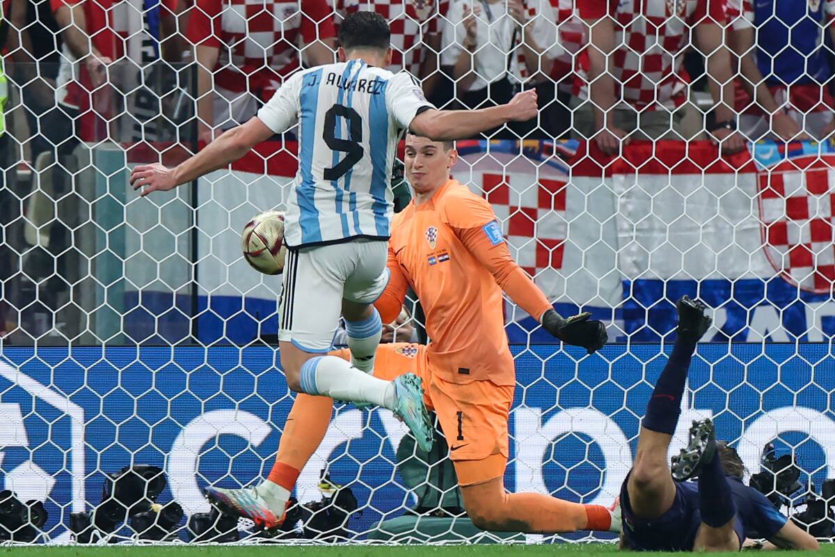 Argentina's forward #09 Julian Alvarez (L) scores his team's second goal past Croatia's goalkeeper #01 Dominik Livakovic during the Qatar 2022 World Cup football semi-final match between Argentina and Croatia at Lusail Stadium in Lusail, north of Doha on December 13, 2022. (Photo by Giuseppe CACACE / AFP)