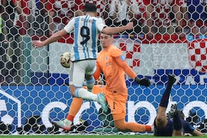 Argentina's forward #09 Julian Alvarez (L) scores his team's second goal past Croatia's goalkeeper #01 Dominik Livakovic during the Qatar 2022 World Cup football semi-final match between Argentina and Croatia at Lusail Stadium in Lusail, north of Doha on December 13, 2022. (Photo by Giuseppe CACACE / AFP)