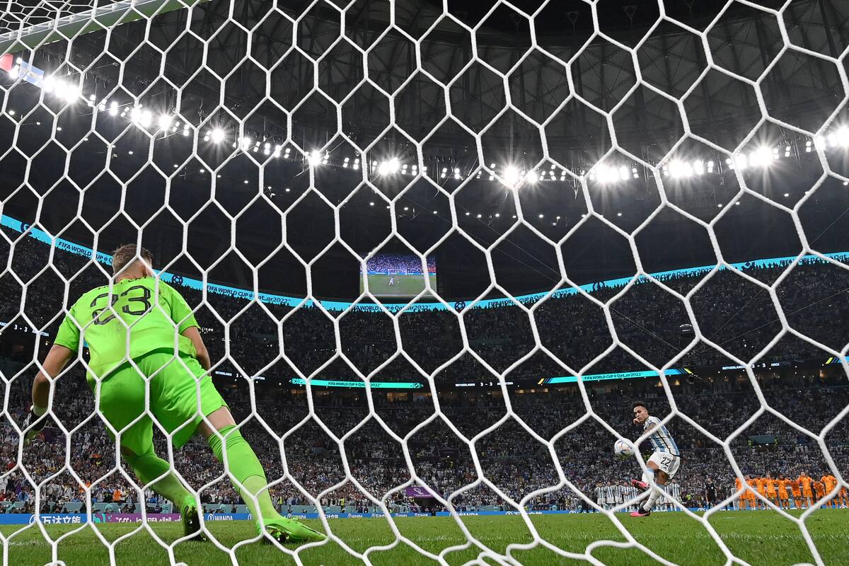 Argentina's forward #22 Lautaro Martinez scores the winning penalty past Argentina's goalkeeper #23 Emiliano Martinez during a penalty shootout at the end of the Qatar 2022 World Cup quarter-final football match between The Netherlands and Argentina at Lusail Stadium, north of Doha on December 9, 2022. (Photo by Alberto PIZZOLI / AFP)