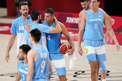 Argentina's Luis Scola (4) hugs teammates at the end of a men's basketball quarterfinal round game against Australia at the 2020 Summer Olympics, Tuesday, Aug. 3, 2021, in Saitama, Japan. (AP Photo/Charlie Neibergall)