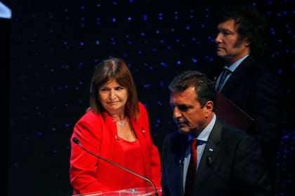 Argentina's presidential candidates Patricia Bullrich (L) for the Juntos por el Cambio party, Javier Milei, for the La Libertad Avanza party, and Sergio Massa (C), for the Union por la Patria party, get ready to leave after the presidential debate at the Assembly Hall of the Universidad de Buenos Aires (UBA) Law School, in Buenos Aires on October 8, 2023, ahead of the October 22 presidential election. (Photo by AGUSTIN MARCARIAN / POOL / AFP)