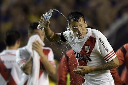 Argentinas River Plate defender Leonel Vangioni pours water on his face after receiving tear gas before the start of the second time of the Copa Libertadores 2015 round before the quarterfinals second leg football match against Argentinas Boca Juniors at the "Bombonera" stadium in Buenos A