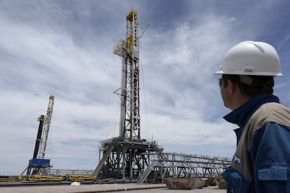 Argentinian oil company YPF's drilling chief Martin Costa observes two oil drilling rigs at his charge in Vaca Muerta Shale oil reservoir at Loma Campana, in the Patagonian province of Neuquen, some 1180 Km south-west of Buenos Aires, Argentina on December 4, 2014. YPF has an agreement with US Chevron to exploit Vaca Muerta, the world's second largest reserve of shale gas and fourth largest reserve of oil, estimated to contain the equivalent of 27 billion barrels.  AFP PHOTO / JUAN MABROM