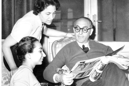 Argentinian politician Arturo Frondizi (Arturo Ercole Frondizi) showing some photos to his wife Elena Faggionato and his daughter Elena Frondizi sitting beside him. Argentina, 1950s. (Photo by Mondadori via Getty Images)