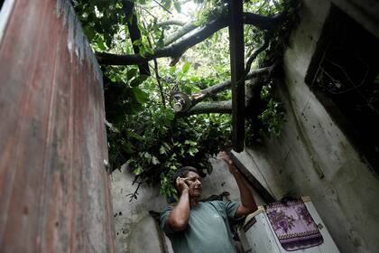 Ari Ribeiro da Paz, de 61 años, habla por celular dentro de su casa dañada luego de las fuertes lluvias en Barra de Guaratiba, en Río de Janeiro, Brasil, el 7 de febrero.