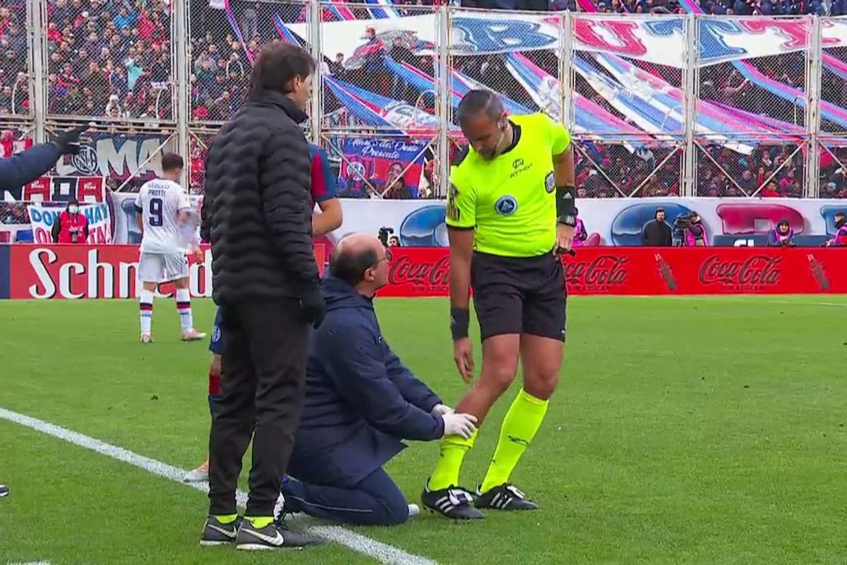 Ariel Penel es atendido por un médico mientras Héctor Paletta, cuarto árbitro, le pregunta a su compañero cómo se siente