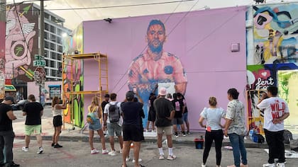 Arlex lleva a cabo su arte, la gente que pasea por el distrito de Wynwood, donde está el mural, lo mira