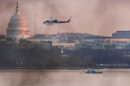 ARLINGTON, VIRGINIA - JANUARY 30: A helicopter flies near the crash site of the American Airlines plane on the Potomac River after the plane crashed on approach to Reagan National Airport on January 30, 2025 in Arlington, Virginia. The American Airlines flight from Wichita, Kansas collided with a military helicopter while approaching Ronald Reagan National Airport. Dozens of people are feared to have died in the midair collision. Andrew Harnik/Getty Images/AFP (Photo by Andrew Harnik / GETTY IMAGES NORTH AMERICA / Getty Images via AFP)