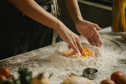 Armá una corona de harina sobre la mesada y rompé los huevos en el medio