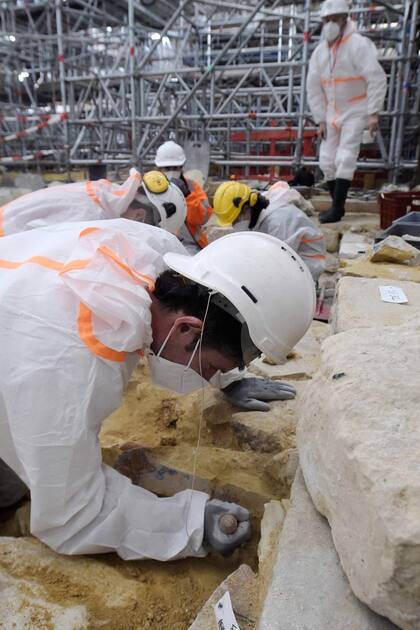 Arqueólogos excavan el suelo de la catedral de Notre Dame tras el descubrimiento de un sarcófago de plomo del siglo XIV, en París, el 15 de marzo de 2022