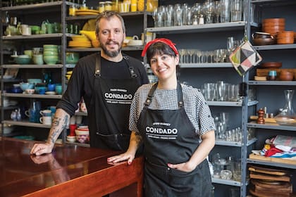Juan de Francesco y Mariana Santos posan en el sector de arriba de la tienda, en el que tienen vajilla de utilería y una gran mesa para eventos.