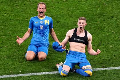 Artem Dovbyk, con la camiseta en la mano y acompañado por Evgen Makarenko, festeja el agónico gol con el que Ucrania le ganó 2-1 a Suecia en Glasgow; por primera vez en la historia, los ucranianos se clasificaron a los cuartos de final de la Eurocopa