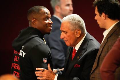 Arthur Blank, derecha, propietario de los Falcons de Atlanta, abraza al coach Raheem Morris después
