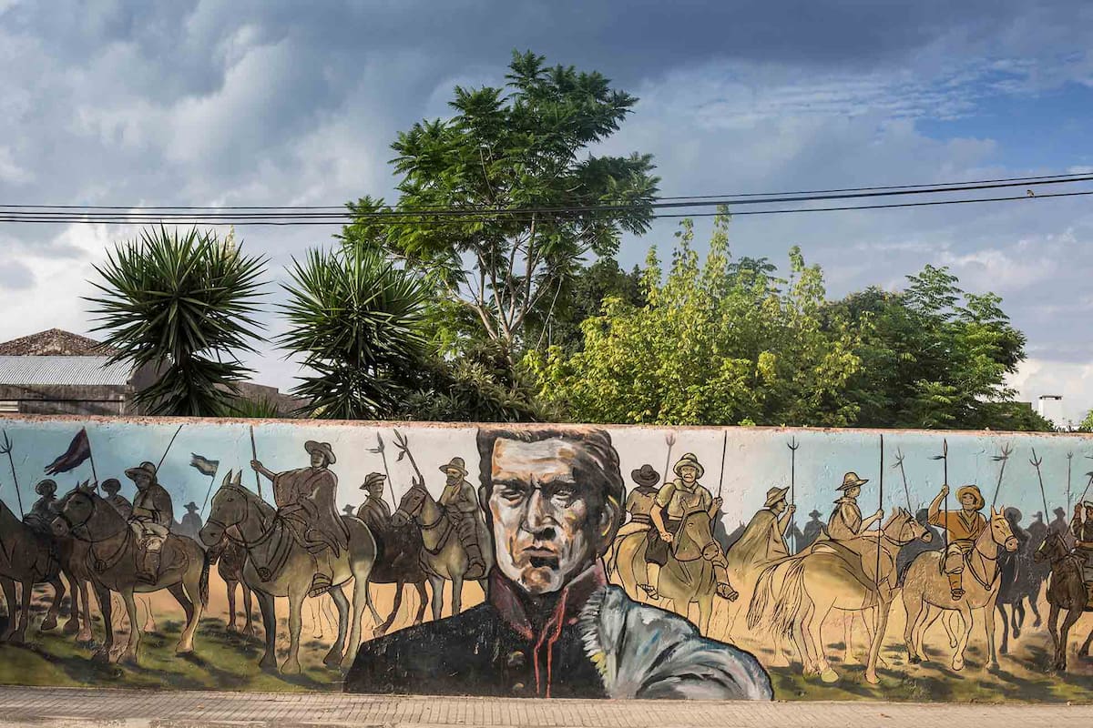 Artigas y los 33 Orientales, grandes héroes del pueblo charrúa, inmortalizados en un paredón de Carmelo.