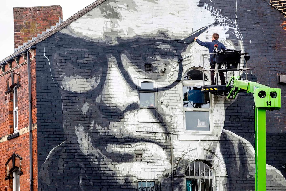 Artist Irek Jasutowicz works on a new mural of Leeds United soccer team manager Marcelo Bielsa near Hyde Park in Leeds, England Thursday Sept. 10, 2020.