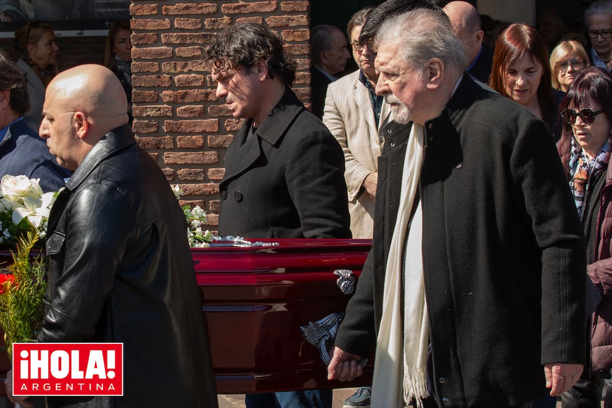 Arturo carga el cajón ayudado por su hijo Juan (de abrigo cruzado negro).