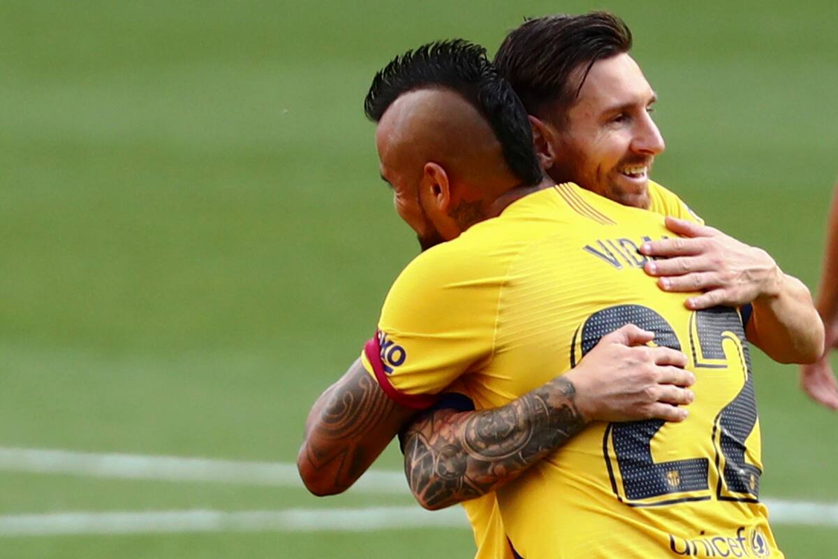 Arturo Vidal de Barcelona celebra con Lionel Messi, después de marcar el primer gol de su equipo durante el partido de fútbol de la Liga española entre Valladolid y FC Barcelona en el estadio José Zorrilla en Valladolid, España, el sábado 11 de julio de 2020.