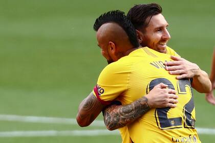 Arturo Vidal de Barcelona celebra con Lionel Messi, después de marcar el primer gol de su equipo durante el partido de fútbol de la Liga española entre Valladolid y FC Barcelona en el estadio José Zorrilla en Valladolid, España, el sábado 11 de julio de 2020.