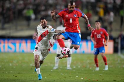 Arturo Vidal, de la selección de Chile, controla el balón ante Sergio Peña, de Perú, en un encuentro de la eliminatoria mundialista, el viernes 15 de noviembre de 2024, en Lima (AP Foto/Martin Mejía)