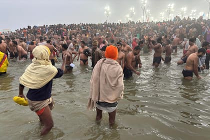 Ascetas hindúes desnudos y cubiertos en ceniza toman baño sagrado en festival Maha Kumbh