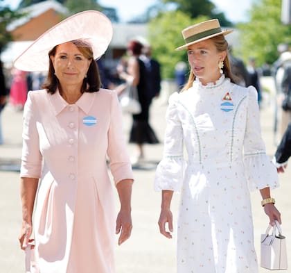 En otra jornada, Carole Middleton llega radiante con el mismo vestido abrigo de Catherine Walker & Co que lució en la boda de Pippa en 2017, acompañada por su nuera Alizée Thevenet, mujer de James Middleton