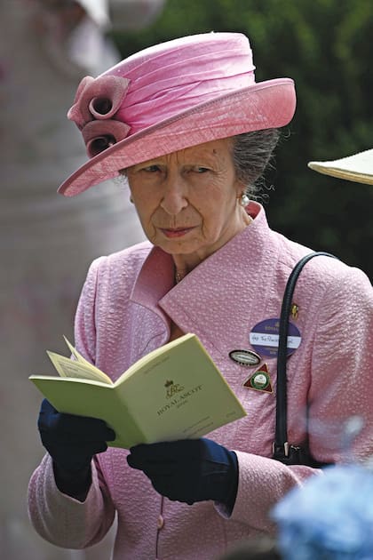 La princesa Ana lució un traje con sombrero a juego adornado con tres flores que ya había usado en el evento hace un cuarto de siglo. Lo completó con pendientes de perlas y su característico broche de caballo de oro