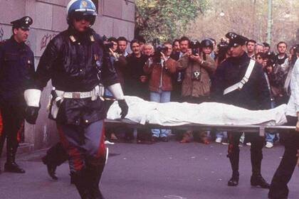 Los carabineros retiran el cuerpo de Maurizio Gucci; el crimen perpetrado por un pistolero y un chofer encargado por su ex esposa desde hacia 10 años, Patrizia Reggiani