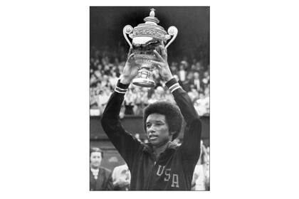 Ashe, encumbrando el trofeo de Wimbledon, luego de vencer a Jimmy Connors en la final de 1975