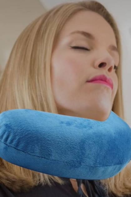 Así, sí: la pasajera utiliza la almohada de viaje bajo su mentón, que es la manera correcta de usar el adminículo