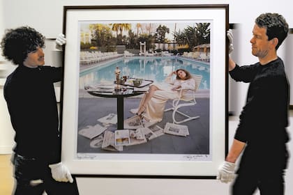 Asistentes de la casa de subastas Phillips, en Londres, trasladan la icónica fotografía de Dunaway tomada por Terry O’Neill