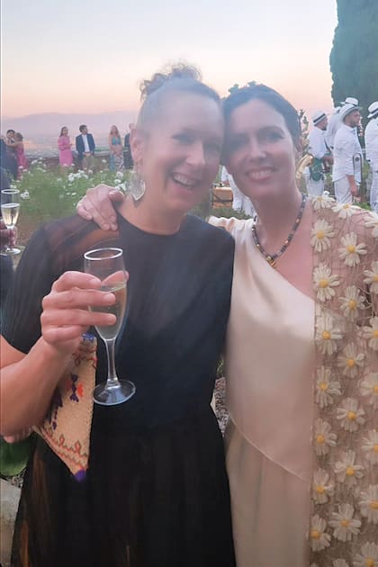 Astrid Perkins, copa de champagne en mano, y Ernestina de Anchorena disfrutan del cóctel.
