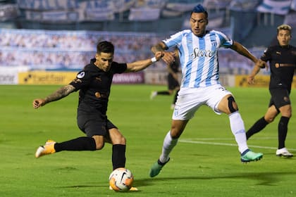 Jonathan Menéndez, que salió lesionado en el primer tiempo en Independiente, intenta escapar de la marca de Monzón