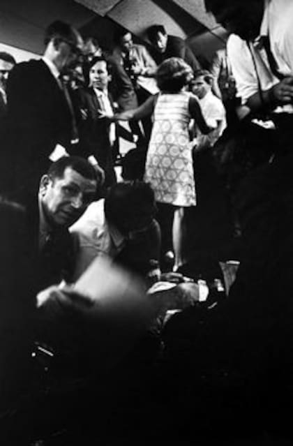 Atrás, Richard Drew (de saco claro) y Harry Benson, parados sobre una mesa, mientras se acerca a ellos Ethel Kennedy. En primer plano, cubierto por otras personas, Bob herido