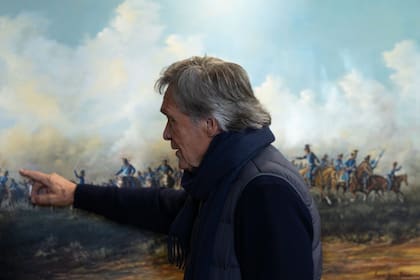 Augusto Gómez Romero señala detalles de su obra "Patriotas"