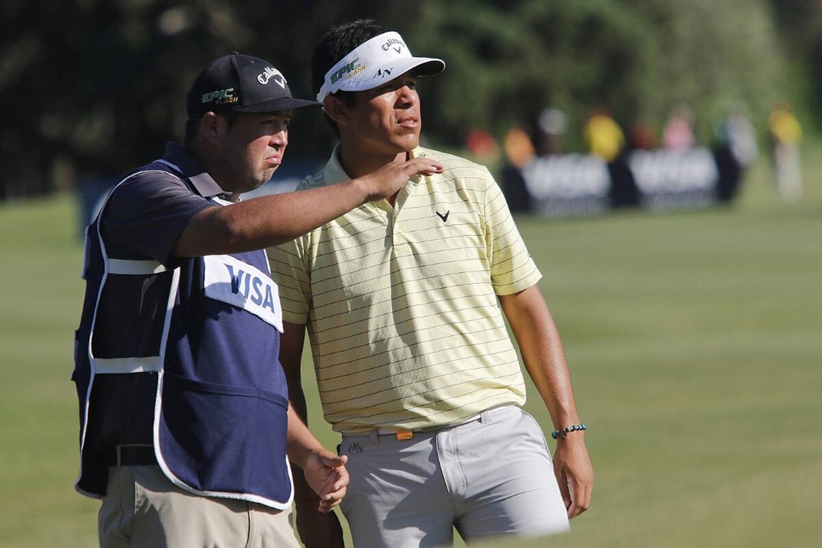 Augusto Núñez analiza un tiro al green con su caddie