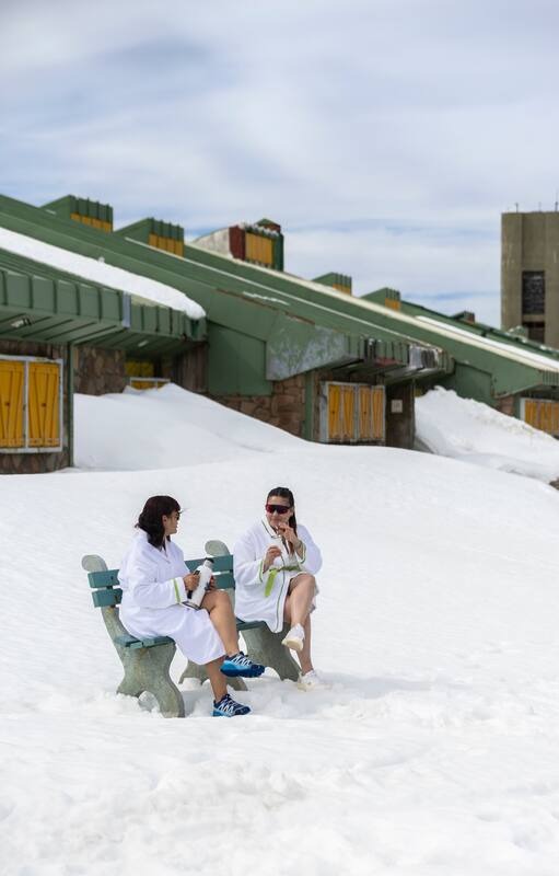 Aún en invierno es grato tomar unos mates en bata antes o después de un baño termal. Detrás, el centro médico Termas de Copahue.