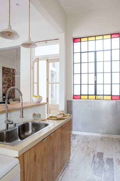Aunque ocupan una porción mínima de la ventana, los paños amarillos y rojos alcanzan para cambiar el carácter de la cocina.