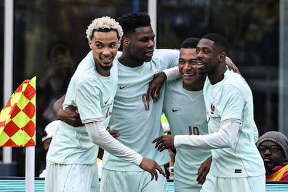 Aurélien Tchouaméni, abraza y mira a Kylian Mbappe y Ousmane Dembele