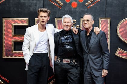 Austin Butler, el director Baz Luhrmann y Tom Hanks, de izquierda a derecha, posan al llegar al estreno de "Elvis" en Londres el martes 31 de mayo de 2022. (Foto por Vianney Le Caer/Invision/AP)