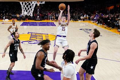 Austin Reaves (15), de los Lakers de Los Ángeles, dispara en contra del Magic de Orlando, durante la segunda mitad del juego de baloncesto de la NBA, el domingo 19 de marzo de 2023, en Los Ángeles. (AP Foto/Marcio Jose Sanchez)