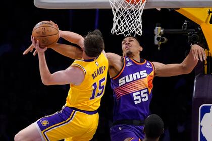 Austin Reaves (izquierda), de los Lakers de Los Ángeles, lanza a canasta ante Darius Bazley durante el juego de la NBA que enfrentó a su equipo con los Suns de Phoenix, el 22 de marzo de 2023, en Los Ángeles. (AP Foto/Mark J. Terrill)